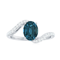 6X8mm Oval Cut London Blue Topaz and Diamond Bypass Engagement Ring