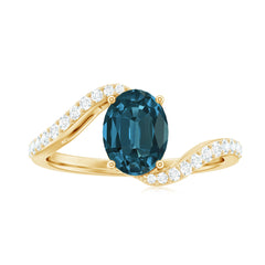 6X8mm Oval Cut London Blue Topaz and Diamond Bypass Engagement Ring